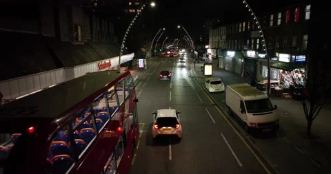 Red bus stop in frond of restaurant and vehicles moving on road on night time Stock Footage 170964466
