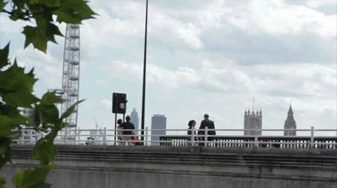 Red buses cross Waterloo Bridge with London Eye and Big Ben in distance 動画素材 65997096