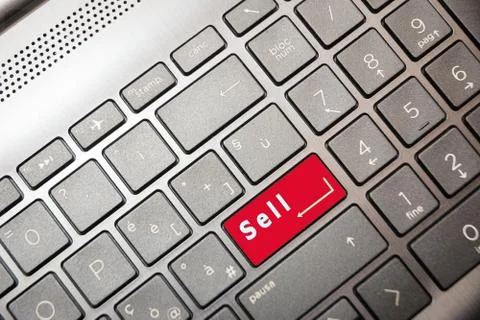 Red button on the computer with the text Sell Stock Photos