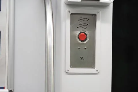 Red button on a metallic panel inside a transportation vehicle Stock Photos