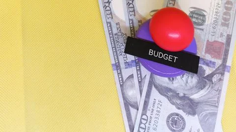 Red button on purple base with BUDGET label on US dollar bills symbolizing .. Stock Photos