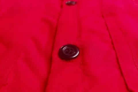 Red button on a red fabric texture. Stock Photos