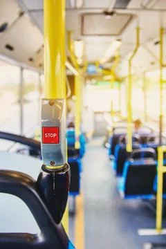 Red button STOP on the bus. Bus with yellow handrails and blue seats. Photo w 스톡 사진