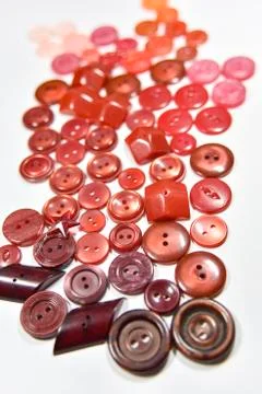 Red buttons of different shape and size on the white background. Selective fo Stock Photos