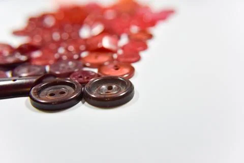 Red buttons of different shape and size on the white background. Selective fo Stock Photos
