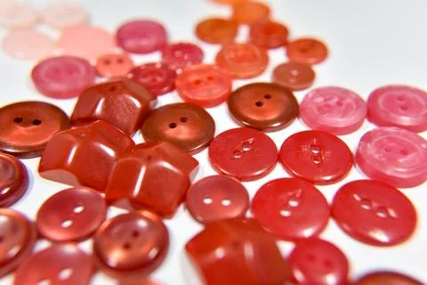 Red buttons of different shape and size on the white background. Selective fo Stock Photos