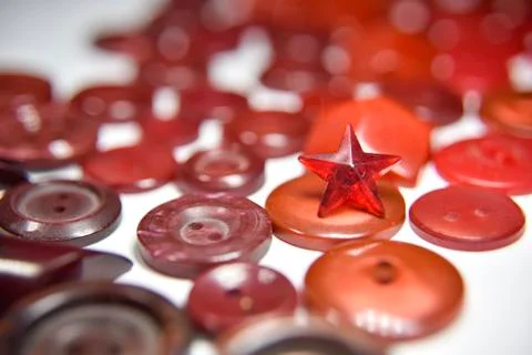 Red buttons of different shape and size on the white background. Selective fo Stock Photos