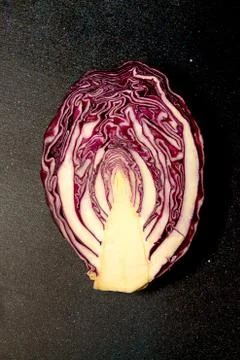 Red cabbage on black background. Half cut cabbage. Stock Photos