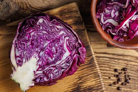 Red cabbage - cut head on cut board and shredded sliced in bowl - on wooden k Foto stock