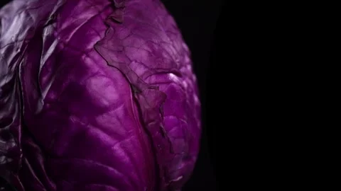 Red cabbage, macro shot, whole head of cabbage rotating over black background Stock Footage 309028384