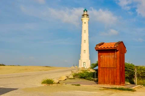 Red cabin with a lighthouse in background. Stock Photos