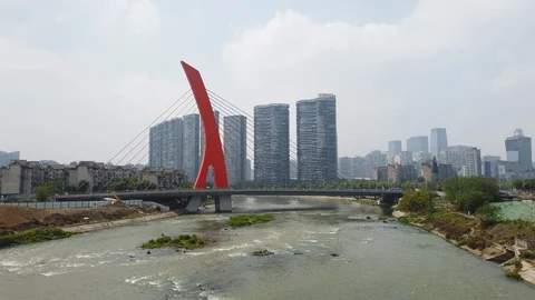 Red cable bridge above FuHe river with skyscrapers in the background in South Stock Footage 128360237