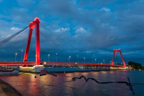 Red cable bridge against cloudy sky at night Stock Photos