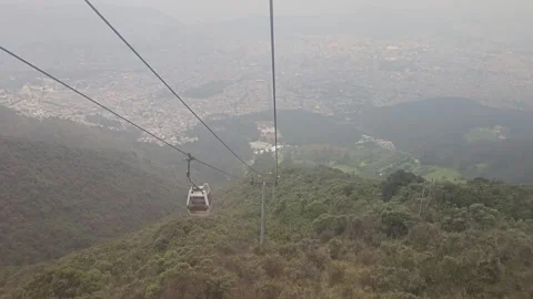 Red Cable Car Cabin Over Forested Slope and Hazy City, Teleférico Quito, Ecuador Video stock 331494289