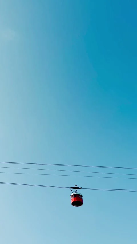 Red cable car crossing the blue sky from Barceloneta Beach to Montjuic Mountain Stock-Footage 344951340