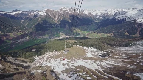 Red cable car descending mountain into valley Stock Footage 310033578