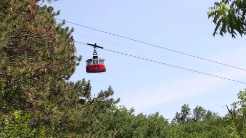 Red cable car gondola moving on Mount Mashuk through trees Stock Footage 341861775