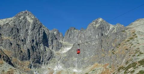 A red cable car on its way from Skalnate pleso to Lomnicky peak. Red gondo... Stock Photos