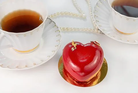 Red cake in the form of a heart with two cups of tea. Valentine's Day Stock Photos