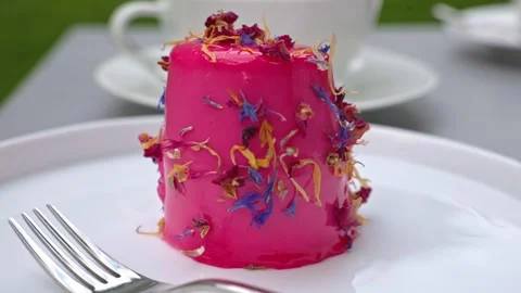 Red cake with raspberry glaze, sprinkled with dried flower petals. Stock Footage 313161675