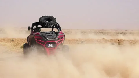 Red Can-Am UTV Buggy Racing Towards Camera Through Massive Dust Cloud in Stock Footage 332894939
