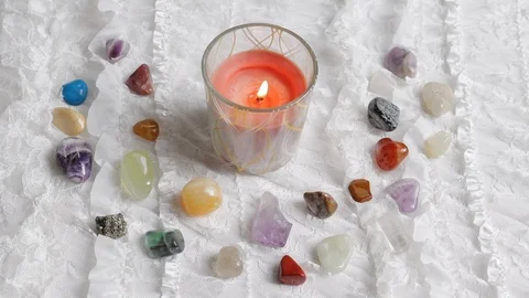 A red candle is blown out on an altar with crystals and white lace Stock Footage 119028994