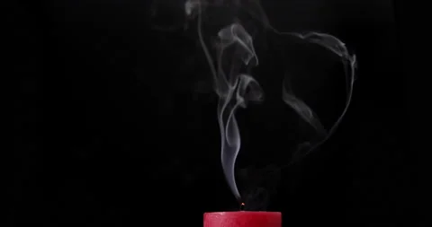Red candle burning on black background. Blow out the candle. Smoke goes up. Видео 142754178