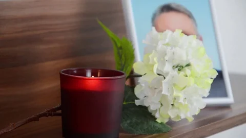 Red candle burning in the front the image of the deceased. Stock Footage 70198549
