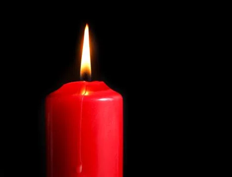 Red candle with fire on dark background. Burning candle in the dark Stock Photos
