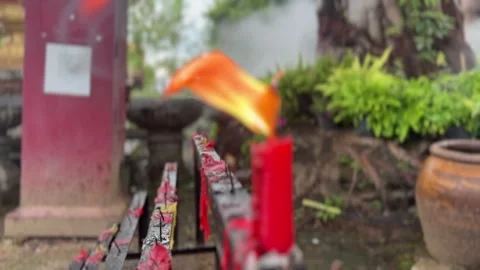 Red candle with flame in blurred focus and outdoor smoky background Stock Footage 314098015