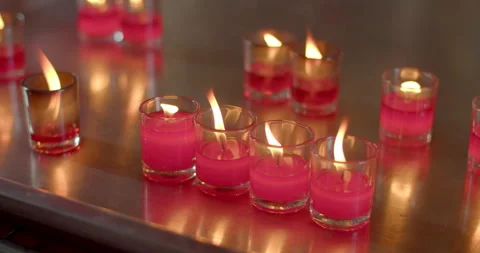 Red candle lit to ask for blessings from monks.Candles in glasses. Stock Footage 282381944