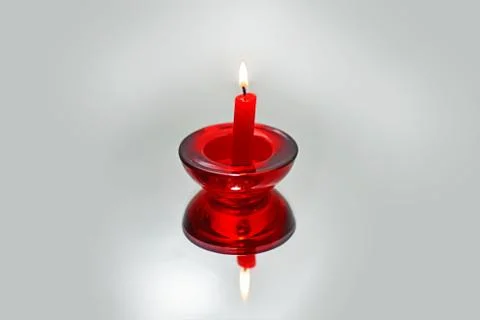 Red candle on mirror with reflection. Stock Photos