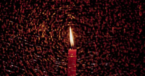 Red Candle visible through a pane of soft focus fractured/broken glass Stock Footage 339026676
