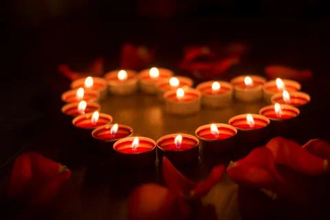 Red candles are arranged in the shape of a heart Stock Photos