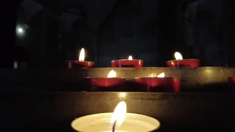 Red candles burning on a candle stand in a church Stock Footage 156281393