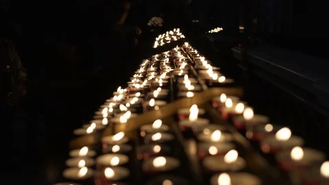 Red candles waving in a dark background in a church. Religiosity and festivity. Video stock 101900023