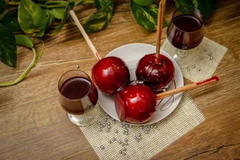 Red candy apple on ceramic plate and glass of cherry liqueur Foto stock