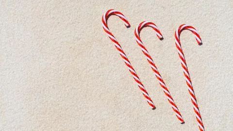 Red candy canes on the white textured background. Christmas moody background. Stock Photos
