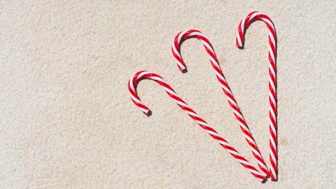 Red candy canes on the white textured background. Christmas moody background. Stock Photos