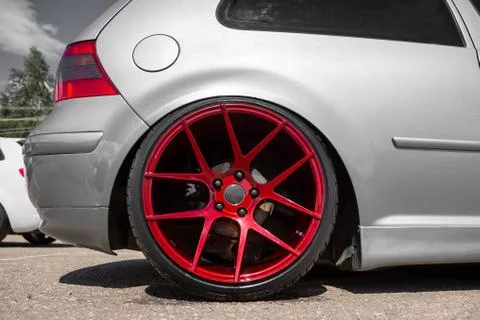 Red candy colored light alloy wheels on silver hatchback Stock-Fotos