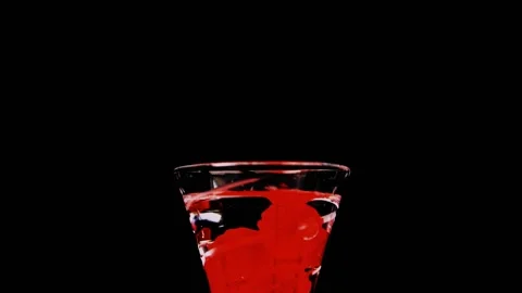 Red candy falling into a glass of water filled with candy slow motion HD Stock Footage 204822732