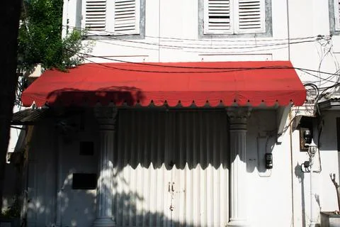 Red canopy store front on white old vintage building Foto stock