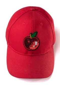 Red cap with sequin apple patch on white background Fotos de archivo