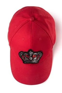 Red cap with a sequin crown patch on white background Fotos de archivo