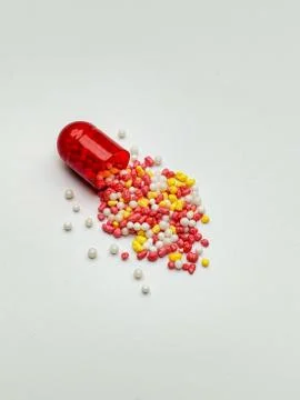 The red capsule is open with lots of pellets Stock Photos