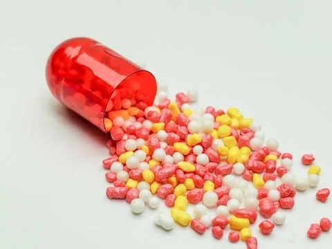 The red capsule is open with lots of pellets Stock Photos
