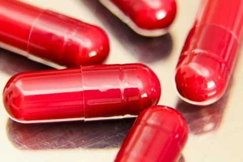 Red capsules on metallic surface Stock Photos