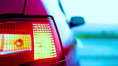 Red car with blinking rear turn signal in close up shot with blurred backgrou Stock-Footage 341802199