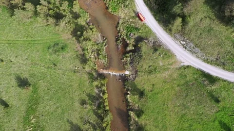 Red car with canoe on the rooftop by the river Stock Footage 276387684