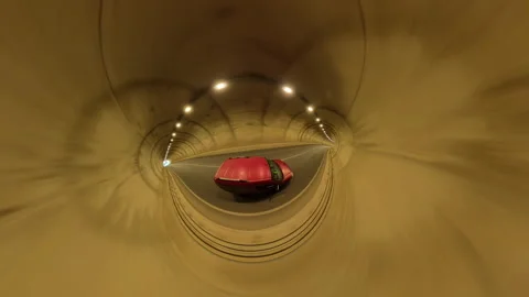 Red Car Captured in Tiny Planet Effect Driving Through a Curved Concrete Tunnel Video stock 297673268